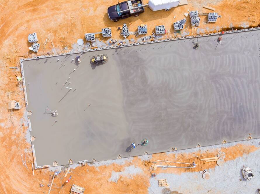 Concrete is poured into wet foundation, a mason finishes polished concrete using concrete polishing