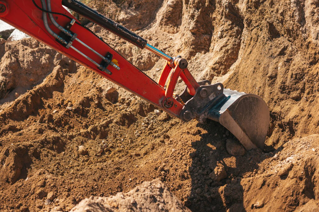 Excavator shovel digging on dirt
